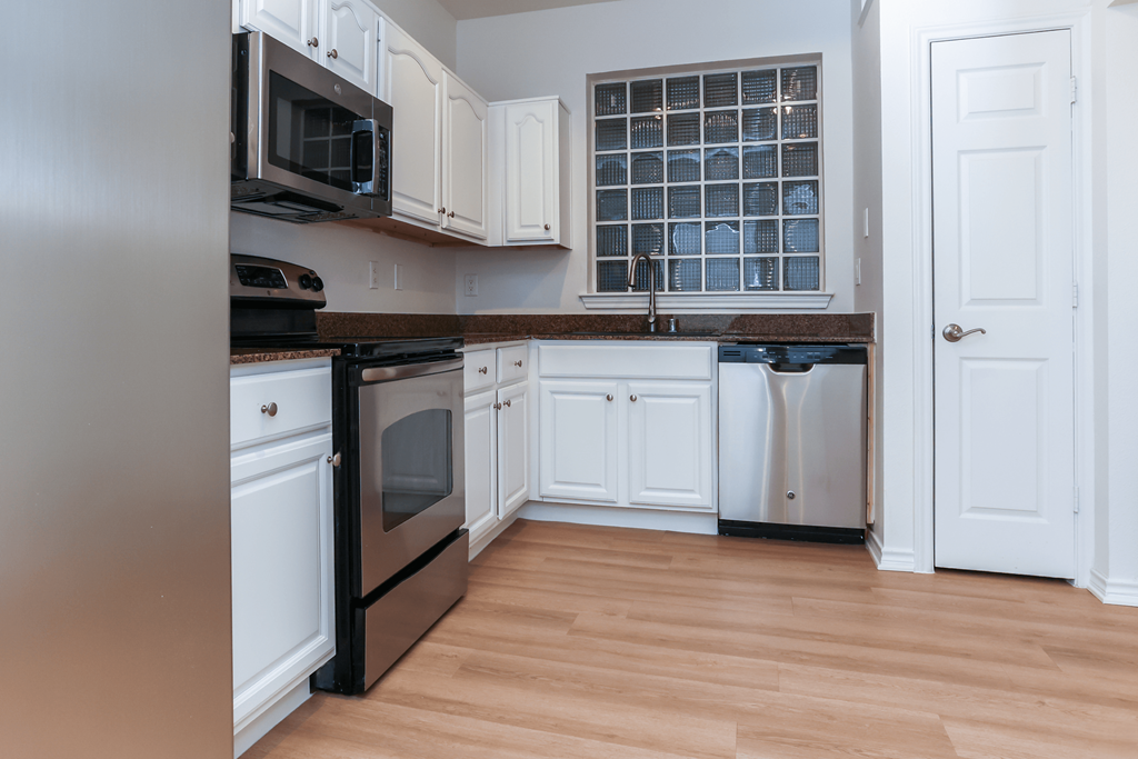 A kitchen with white cabinets and a black oven.